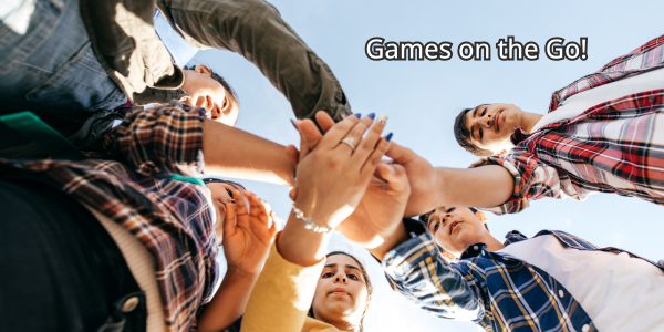 Teens standing in a circle with their hands in the center